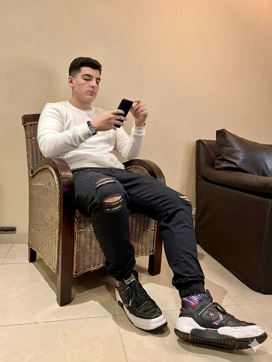 Tiziano relajado en un sillón, mirando el teléfono.